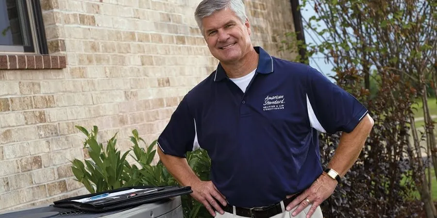 american standard tech standing next to ac unit