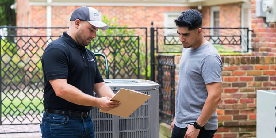 hvac tech showing homeowner a clipboard