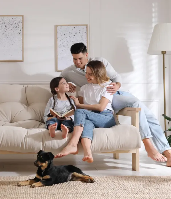 family sitting on sofa with their dog on the floor